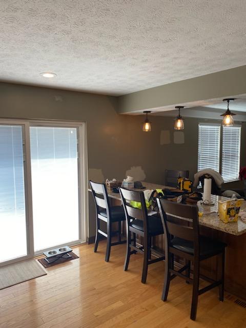 Kitchen dining nook painted olive grey with pendant lights over the counter