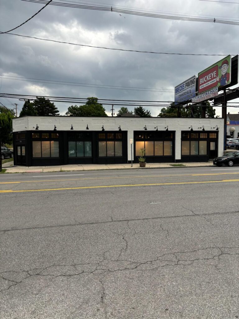 Front view of the finished storefront with black window trim and warm interior lighting